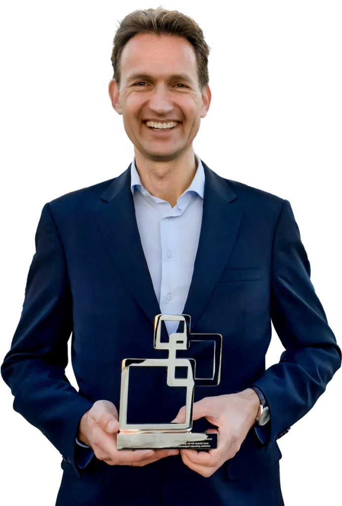 A person in a suit smiles while holding a BroadForward GLOMO award.